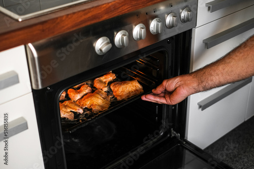 male cook baking meat in the oven