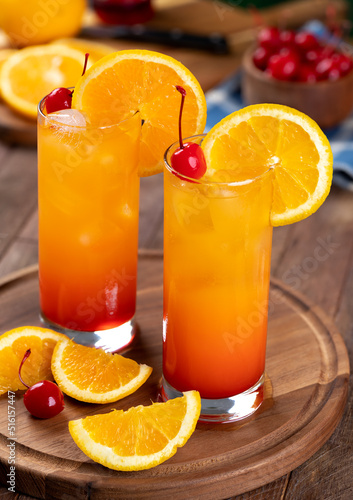 Tequila sunrise cocktail with orange slice and cherry photo