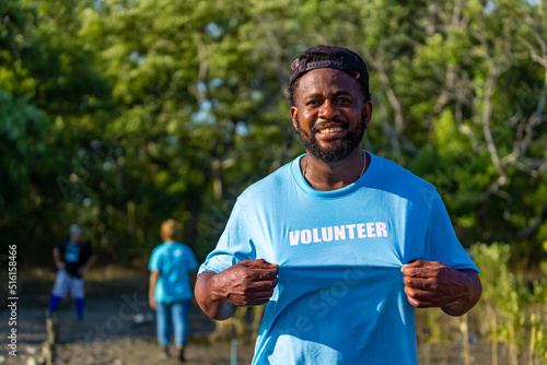 Portrait of African American volunteer man enjoy charitable social work outdoor in the mangrove planting project