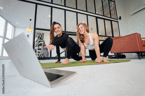 Two charming sports women, do yoga poses, exercises at home © teksomolika