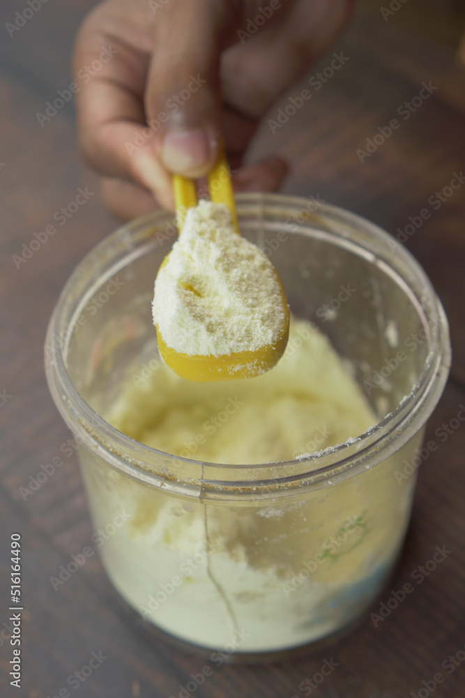 Close up of baby milk powder and spoon on tile background. Close up of baby milk powder and spoon on tile background.