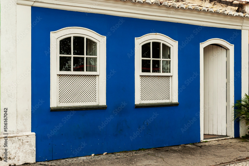 Old house in blue color and white details with white wooden door and windows. Nice facade. City of Porto Seguro. Bahia.