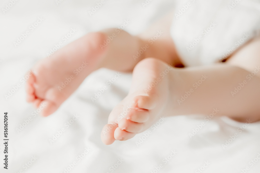 baby legs on the background of white bed linen. copy space. Ukrainian newborn. baby's little toes baby legs on the background of white bed linen. copy space. Ukrainian newborn. baby's little toes