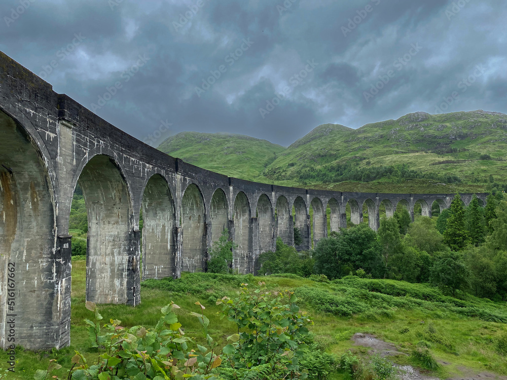 old historic Glenfinnan Viaduct bridge with landscape in Scotland