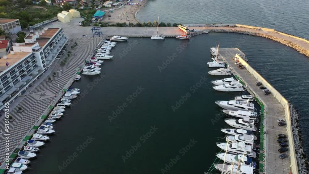 Many yachts are in the marina on the water. Sea. View from above. the camera moves from bottom to top Many yachts are in the marina on the water. Sea. View from above. the camera moves from bottom to top