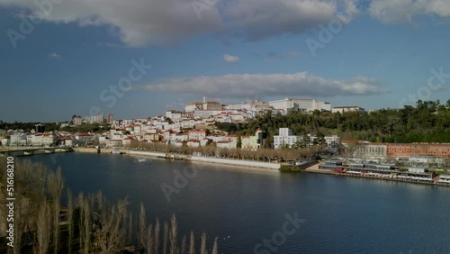 Aerial view of the city of Coimbra from the river side with th view of the university. Cinematic drone shot inn 4K