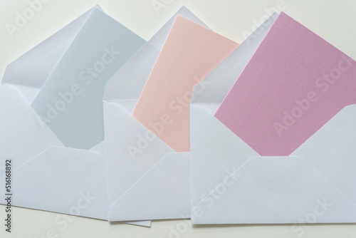 pastel colored paper cards tucked inside white envelopes