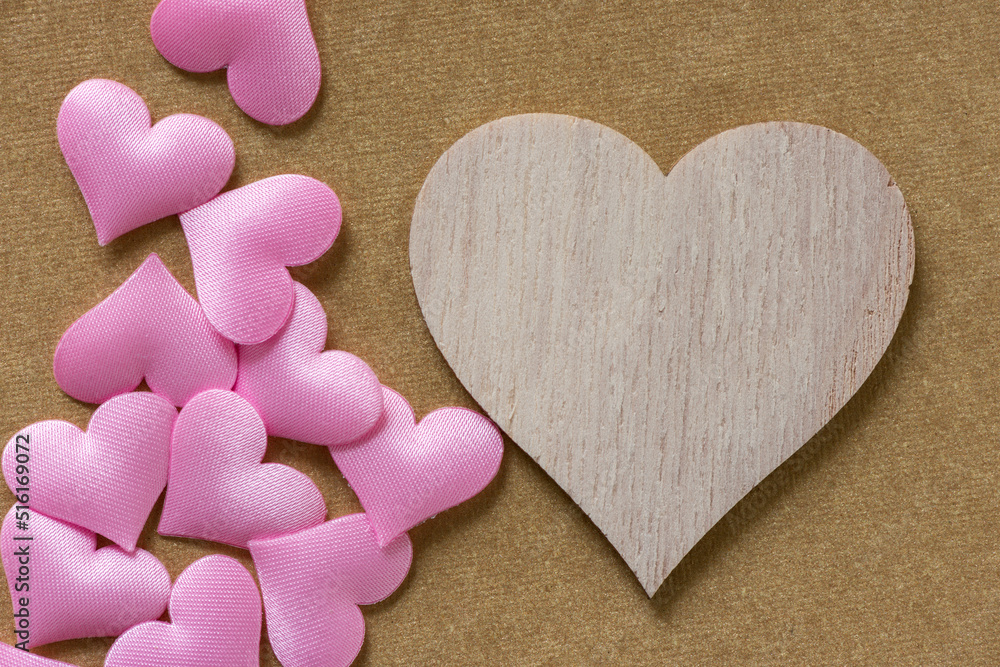 Obraz premium large wood heart shape and small pink fabric hearts on gold paper
