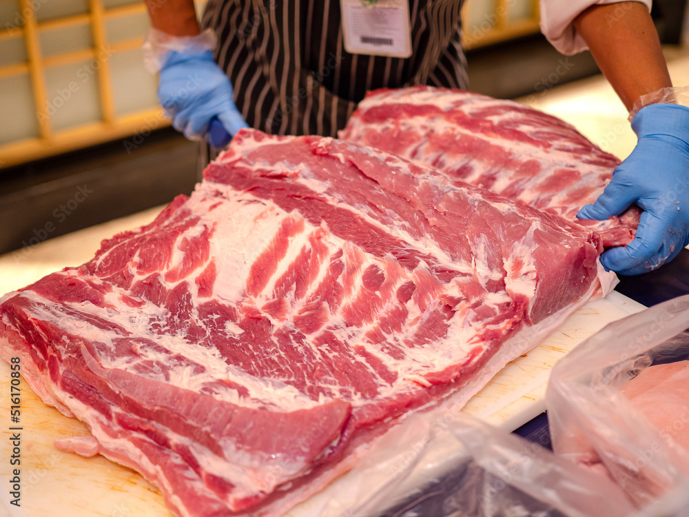Traders are cutting fresh pork to sell in the market.