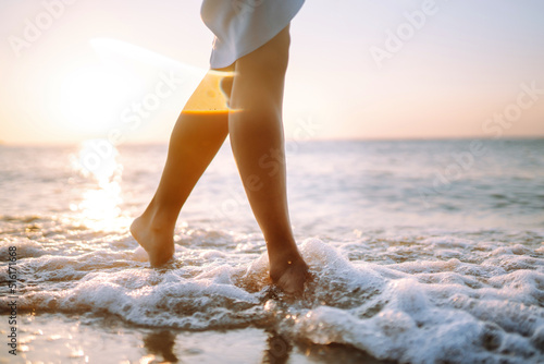 Canvas Print Close- up leg of young woman walking along wave of sea water and sand on the summer beach