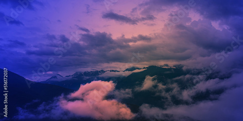Majestic landscape with mountains and clouds at sunset. Atmosphere