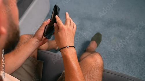 A poor man is holding an empty wallet with coins. Economic crisis. The person has no savings and is bankrupt. A male without money is stressed. The frustration of having no currency