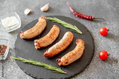 grilled sausages from turkey meat with spices on a stone background 