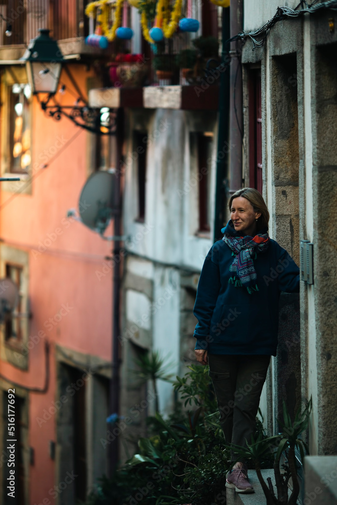 A woman stands at the door of a house in an old European city. A woman stands at the door of a house in an old European city.