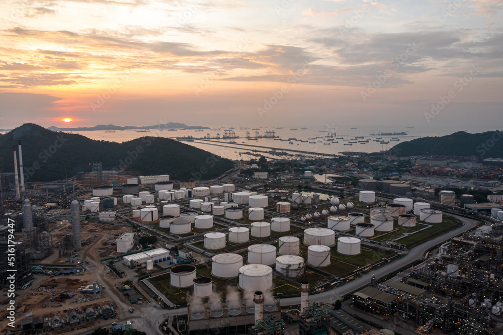 Aerial view of evening oil refinery and factory Petrochemical plant and crude oil pipeline bridge and the sunset background,