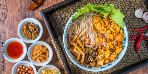 A bowl of Guangxi Liuzhou gourmet snail noodles on a wooden table