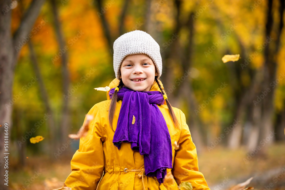 Portrait of smiling little adorable girl in autumn park with yellow and green trees and flying leaves Portrait of smiling little adorable girl in autumn park with yellow and green trees and flying leaves