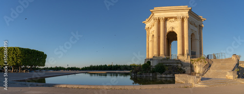 Scenic early morning panoramic view of the beautiful ancient water tower stone building and pool in historic Promenade du Peyrou garden, Montpellier, France