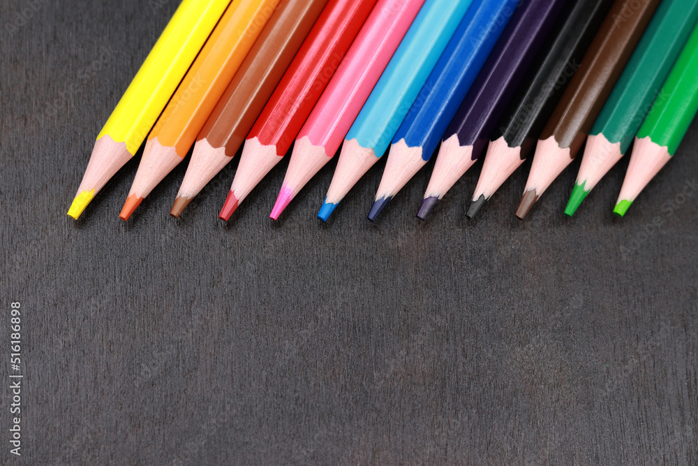 Selective focus. A set of colored pencils on a black wooden background. Sharpened bright pencils. Drawing and learning. Back to school Selective focus. A set of colored pencils on a black wooden background. Sharpened bright pencils. Drawing and learning. Back to school