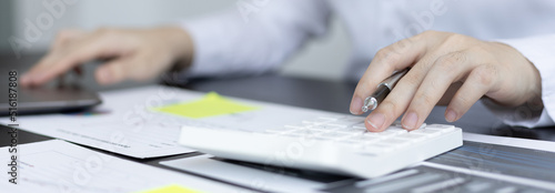 Young Asian businesswoman presses a calculator to calculate income tax and corporate income in a private office, Finance, Accounting, Tex, Statistical graphs of marketers investing in real estate.