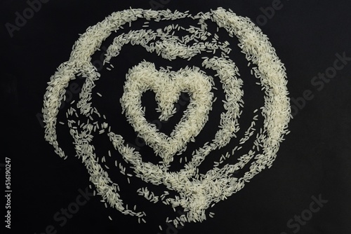 heart made of rice on black background  
