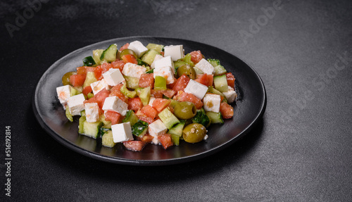 Greek salad with juicy tomatoes, feta cheese, lettuce, green olives, cucumber, red onion and fresh parsley