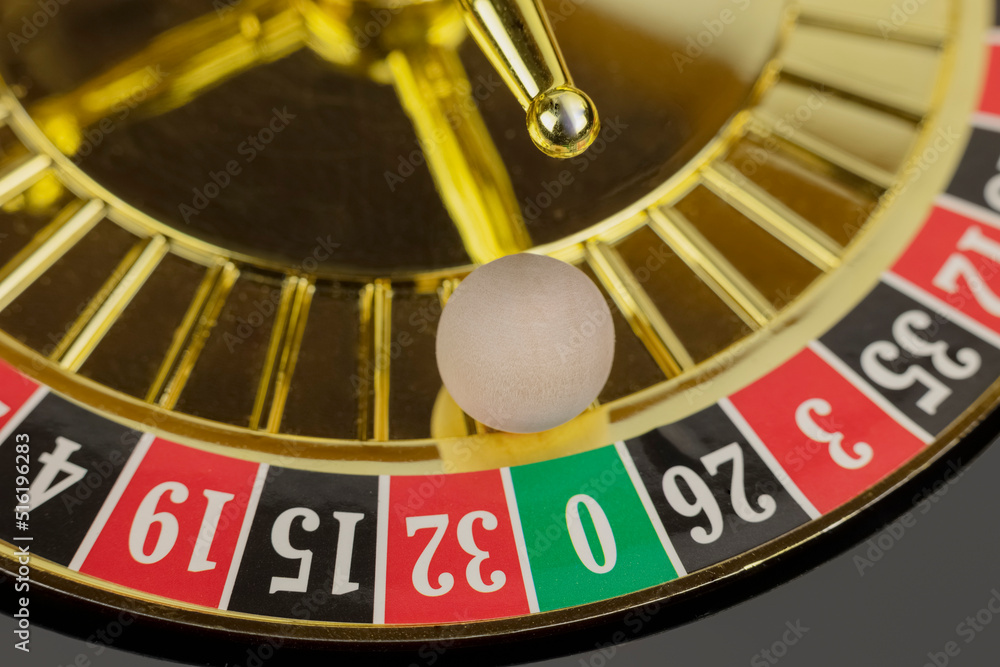 Casino roulette wheel with wooden ball on green zero sector Casino roulette wheel with wooden ball on green zero sector