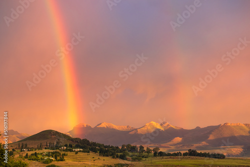 View of a double rainbow at sunset against a backdrop of mountains in the town of Clarens, South Africa, near the Golden Gate Highlands National Park