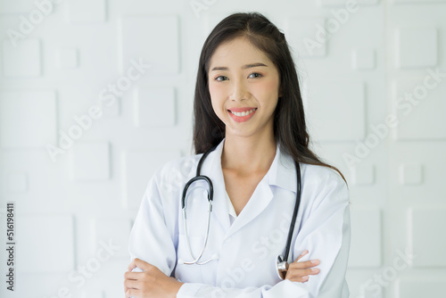 Happy asian nurse wear uniform with stethoscope standing with arms crossed at the hospital.