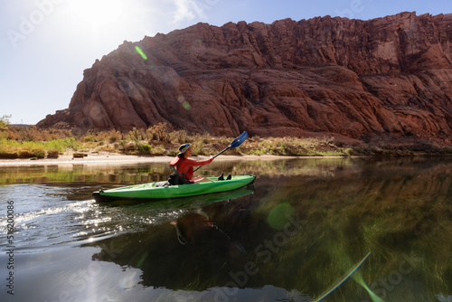 Adventurous Woman on a Kayak paddling in Colorado River. Glen Canyon, Arizona, United States of America. American Mountain Nature Landscape Background. Adventure Travel © edb3_16