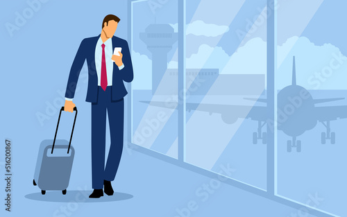 Businessman walking with luggage and using smart phone at the airport