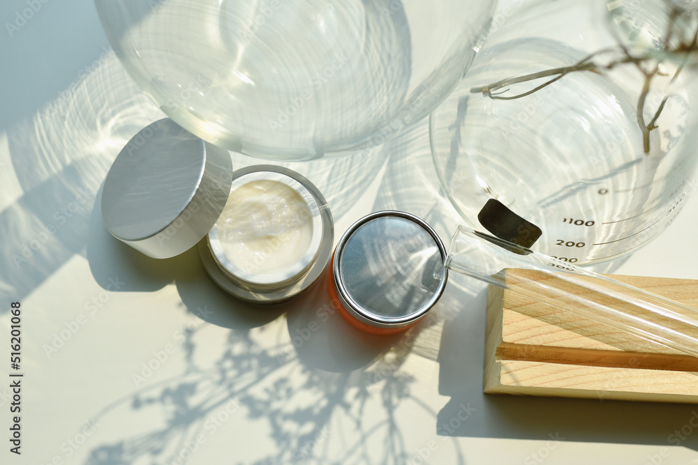 Cosmetic bottle container on sunlight and leaves plant shadow background, Skincare facial cream, Beauty product with warm mood and tone. Cosmetic bottle container on sunlight and leaves plant shadow background, Skincare facial cream, Beauty product with warm mood and tone.