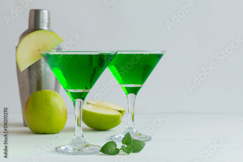 green cocktail with mint.Apple cocktail mixed drink with vodka and apple slice. Apple martini cocktail on the white background. Homemade Green Alcoholic drinks in martini glasses with apple slice. photo