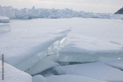 Estructuras de hielo congeladas y placas rotas al amanecer sobre lago helado