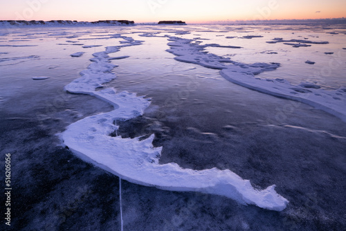 Placas de hielo rotas congeladas al amanecer sobre lago helado