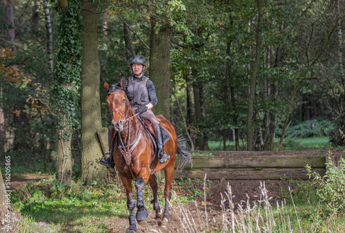 junge Reiterin im Wald auf braunem Pferd hat Angst vor dem, was kommt