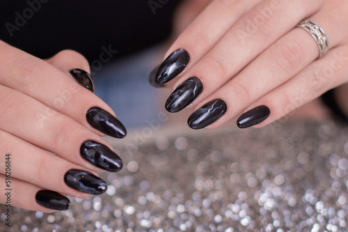  Beautiful female hands with fashion manicure nails  black gel polish  on glitter background