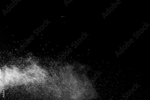 Horizontal steam with drops of spray flying in different directions on a black background for overlay on a photo. Stream, jet of hot water with steam and drops.