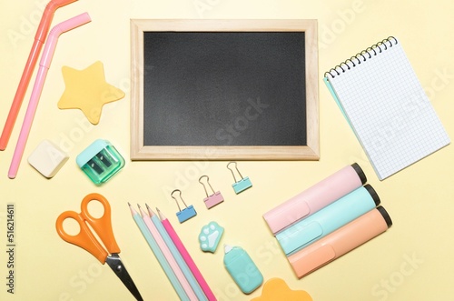 Background with school material, on yellow background. Blackboard for text. Accessories with pastel colours.