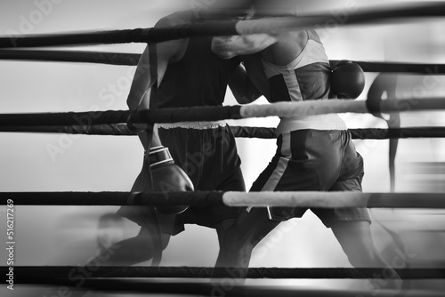 Black and white silhouettes of boxing athletes in the ring. Combat sports. Shallow depth of field. Motion blur effect.