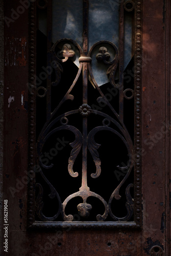 Old door decorative element with floral tracery and a broken window glass