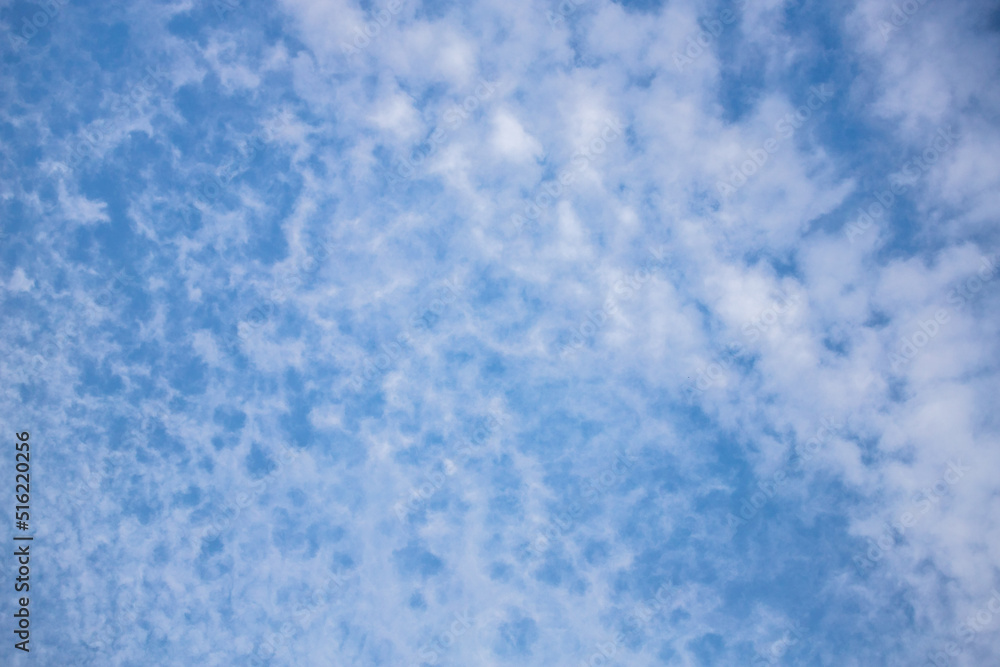 High blue sky. Rippled clouds. Heavenly heights. Sky background. The blue sky is covered with speckled clouds.