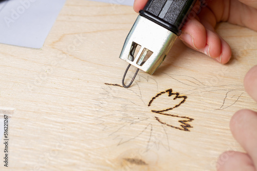 Photos Burn out a drawing on a wooden board with an electric device with a scorcher