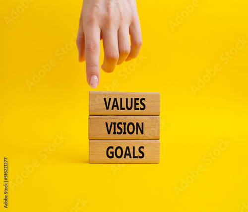 Values Vision Goals symbol. Concept words Values Vision Goals on wooden blocks. Beautiful yellow background. Busimessman hand. Business and Values Vision Goals concept. Copy space.