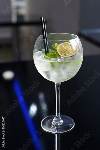 Fresh cocktail with ice, mint and lime on the dark background