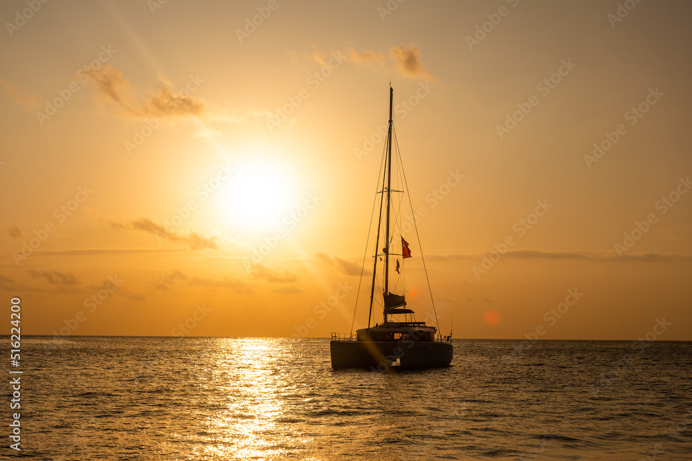 Sunset in the Indian Ocean. Silhouette of a sailing catamaran anchored against the backdrop of the evening sun