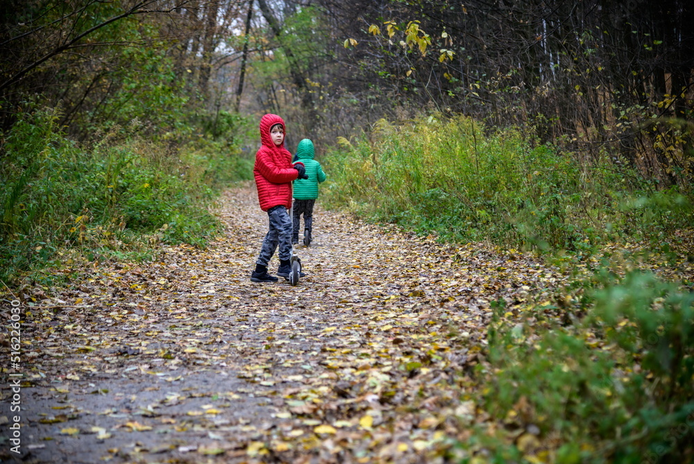 Two children boy and sibling brother in warm hats with backpacks Two children boy and sibling brother in warm hats with backpacks