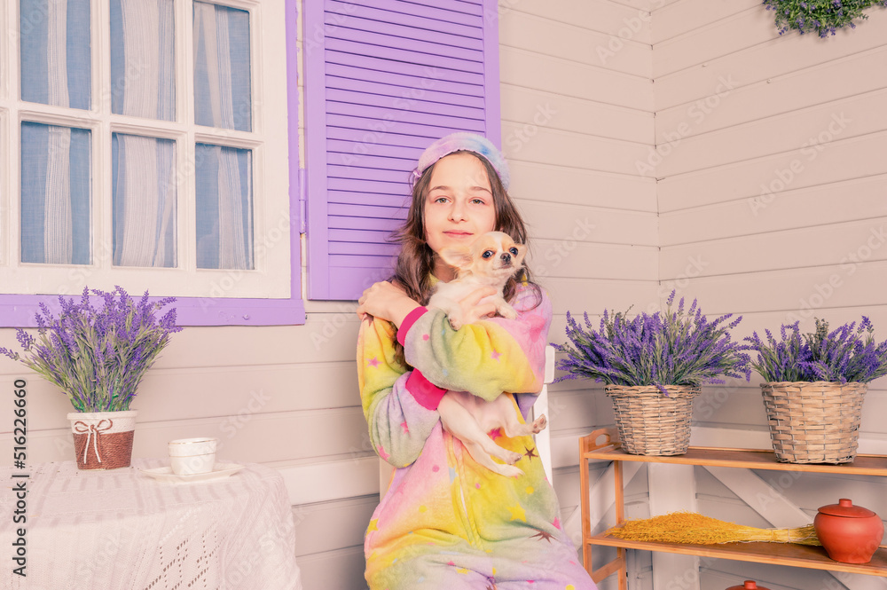 A teenage girl in pajamas and a sleep mask with a chihuahua dog in her arms. A girl and a dog. A teenage girl in pajamas and a sleep mask with a chihuahua dog in her arms. A girl and a dog.