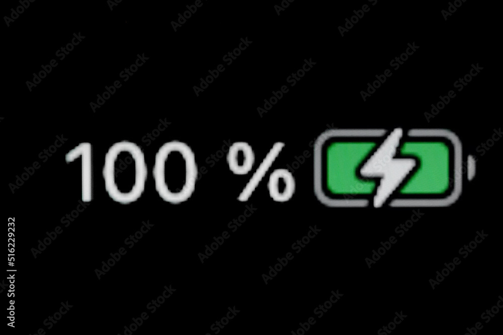 Smartphone charged battery level indicator - charging process - one hundred, 100 percent: close up, macro of gadget display, screen - black background. Energy, power, digital and symbol concept