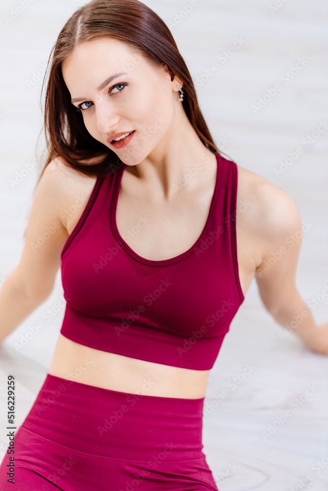 beautiful girl in burgundy tracksuit in fitness room. cosmetics for athletes. beautiful girl in burgundy tracksuit in fitness room. cosmetics for athletes.